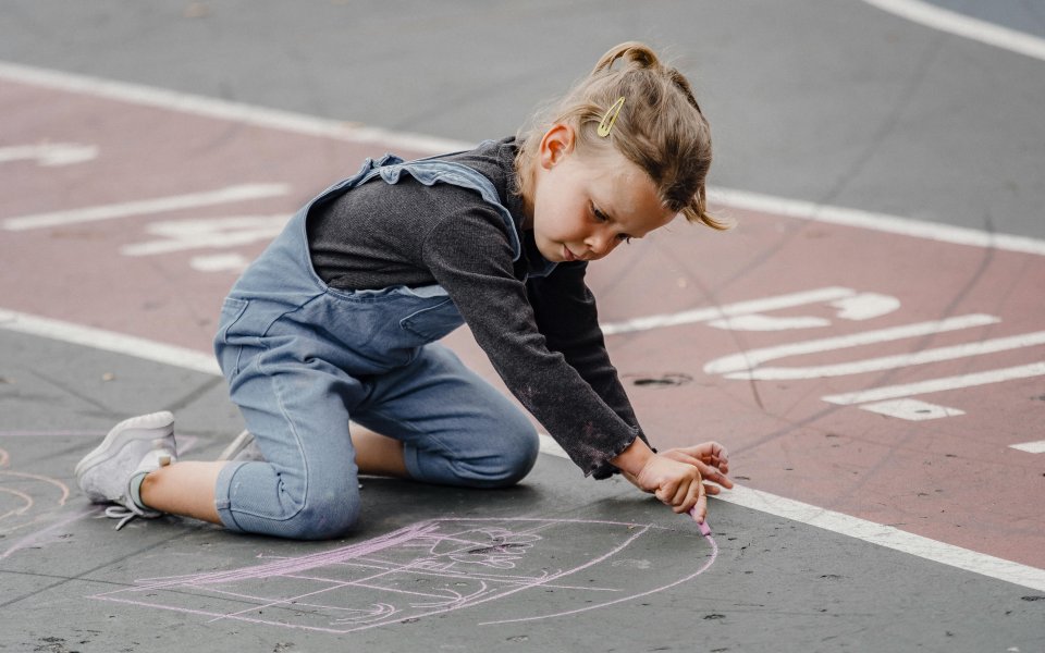 meisje-tekent-met-krijt-op-de-straat.