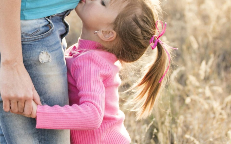 meisje zoent de zwangere buik van haar mama