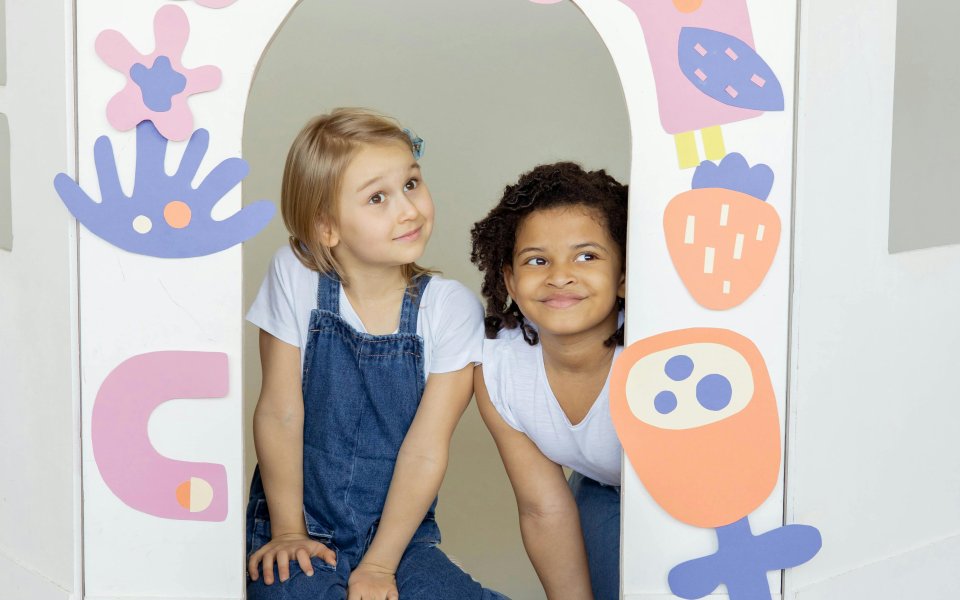 meisjes-zitten-in-papieren-huisje-met-vrolijke-tekeningen