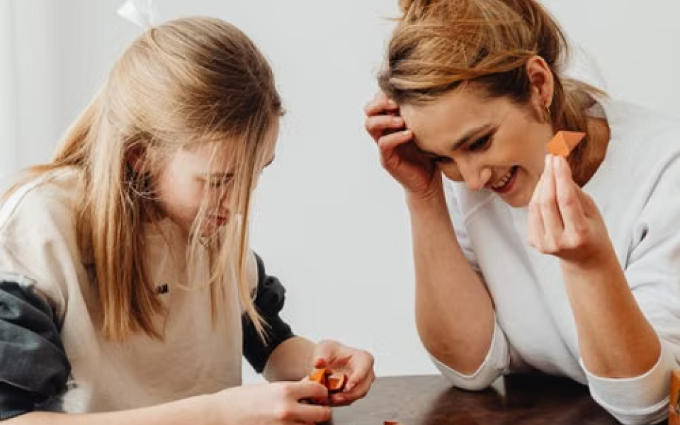 moeder en dochter spelen samen een spelletje aan tafel