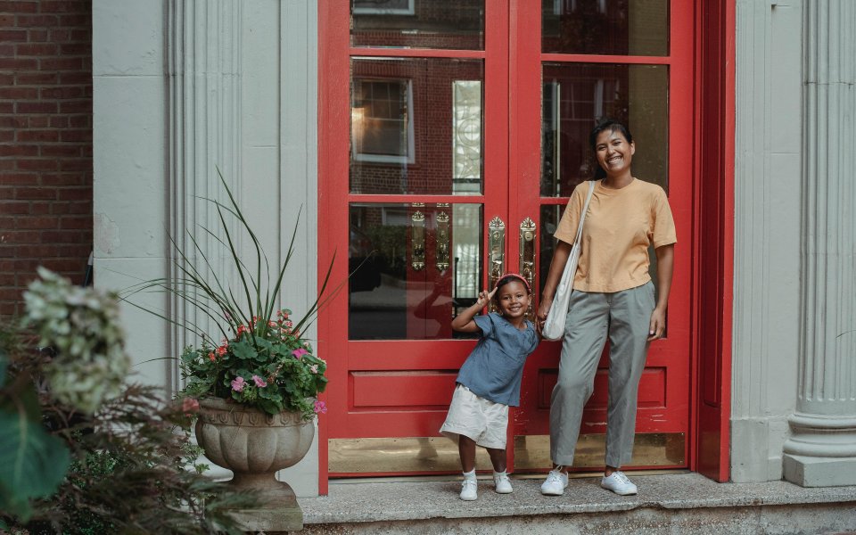 moeder-en-kind-poserend-voor-een-rode-deur