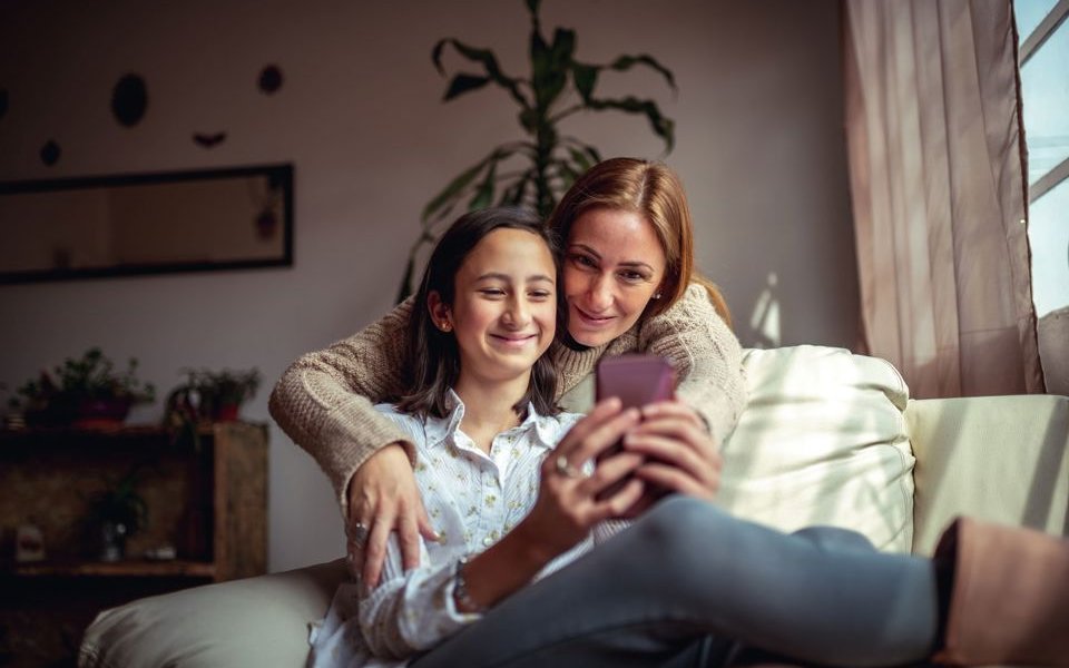 moeder en dochter in warme omhelzing samen op gsm