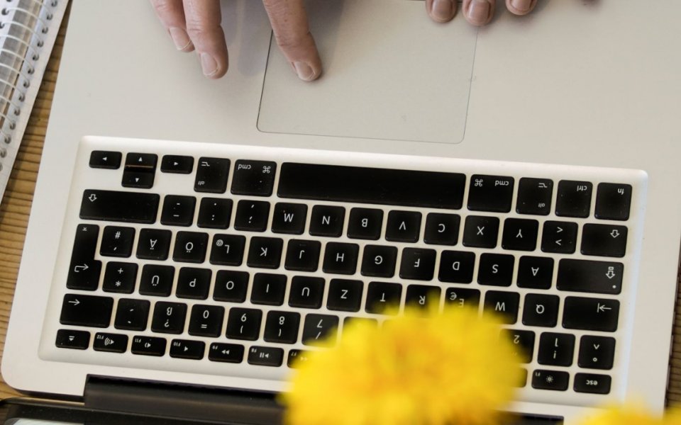 handen op het touchpad van een laptop