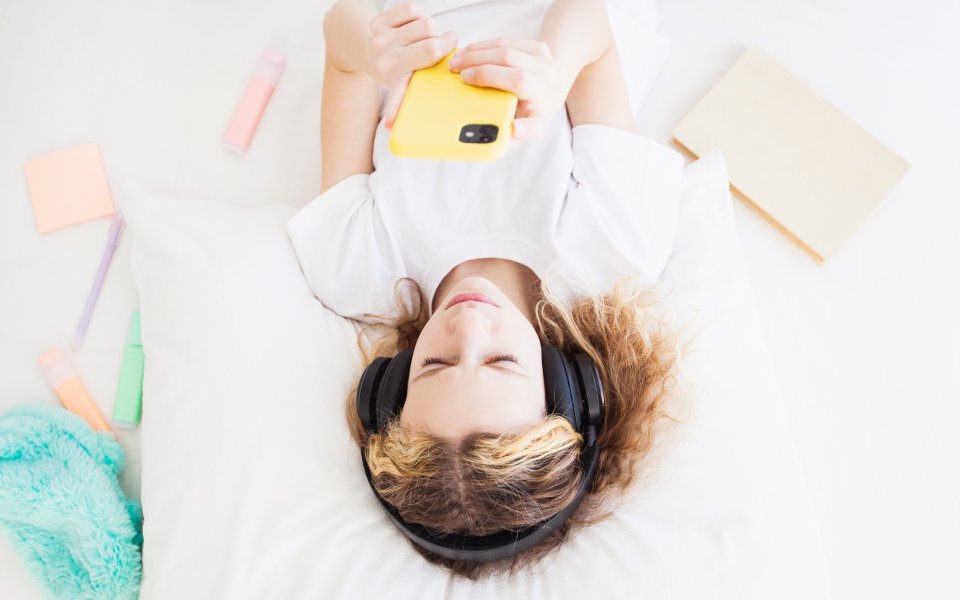 meisje luistert naar muziek in bed