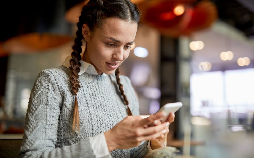 meisje met vlechtjes kijkt op smartphone