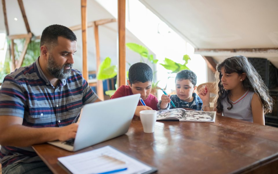 papa-aan-het-werk-met-3-kinderen-mee-aan-tafel.