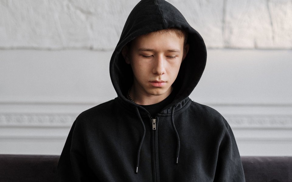 jongen met hoodie, kijkt triest