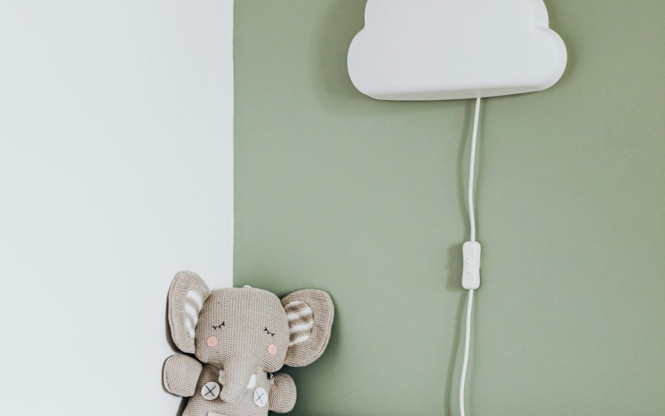babybedje met wolkenlampje aan de muur