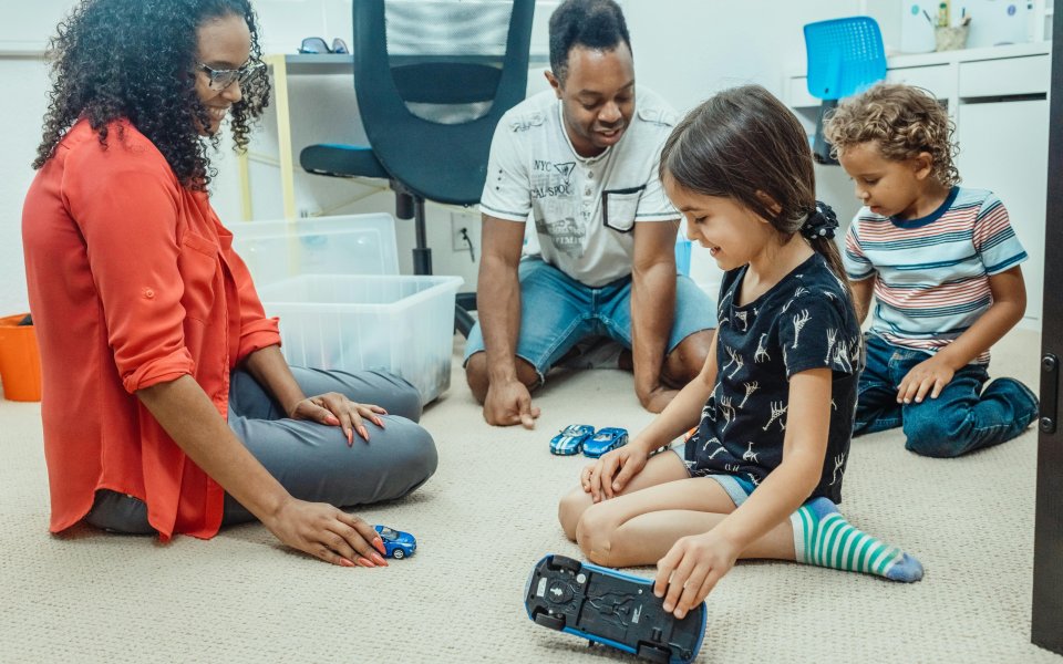 ouders en kinderen spelen op de grond