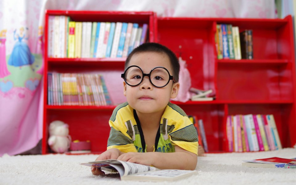 jongetje, lezend in een bibliotheek