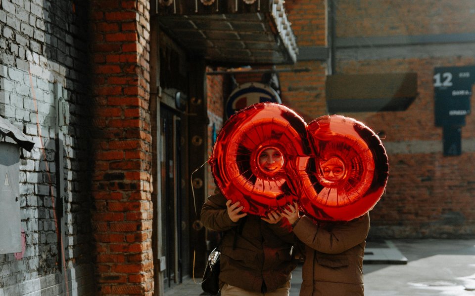 2 mensen kijken door een grote ballon in de vorm van een liggende 8