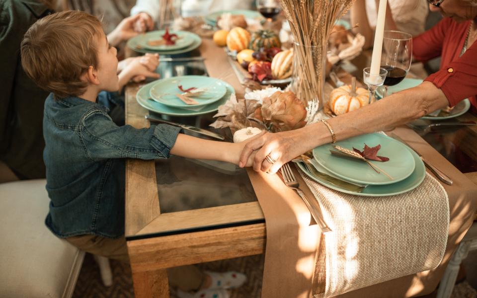 kind en volwassene geven een hand aan tafel