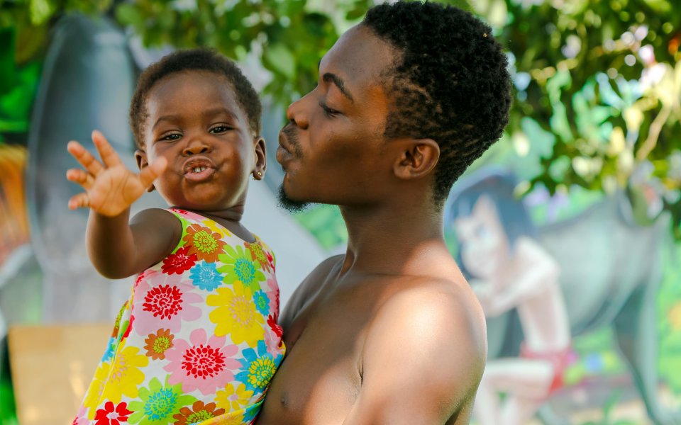 papa kijkt lachend naar dochtertje, Afrikaanse roots