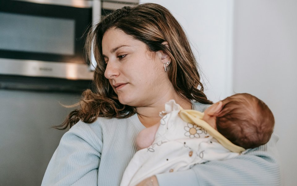 moeder kijkt weg van haar baby