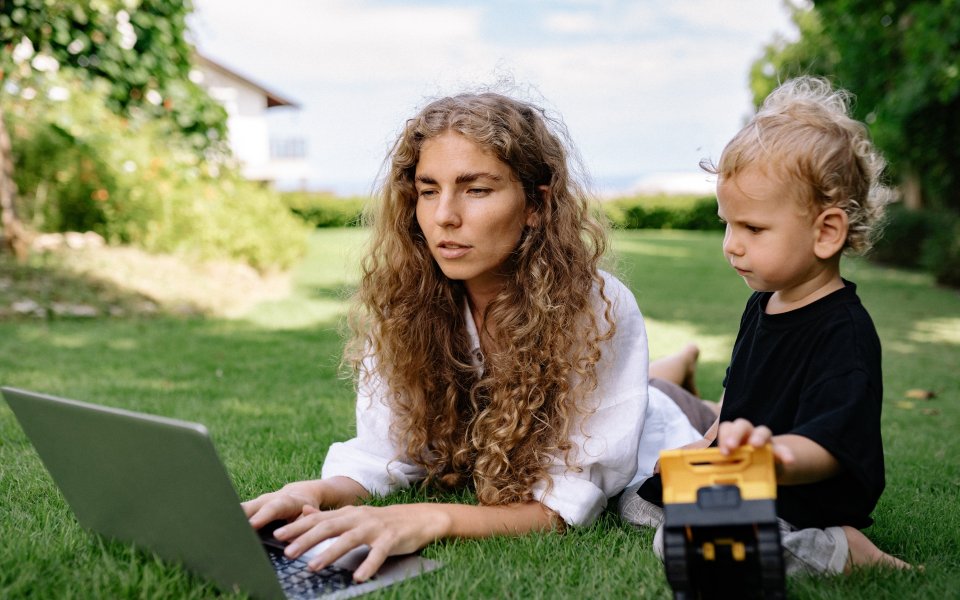 vrouw op laptop met peuter