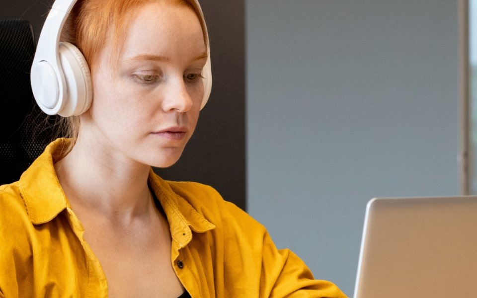 Nieuwsbericht Opgroeien vrouw met hoofdtelefoon voor laptop