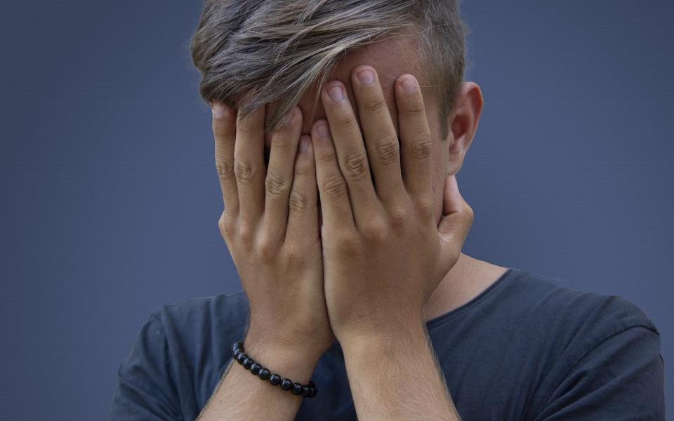 tiener met handen voor gezicht