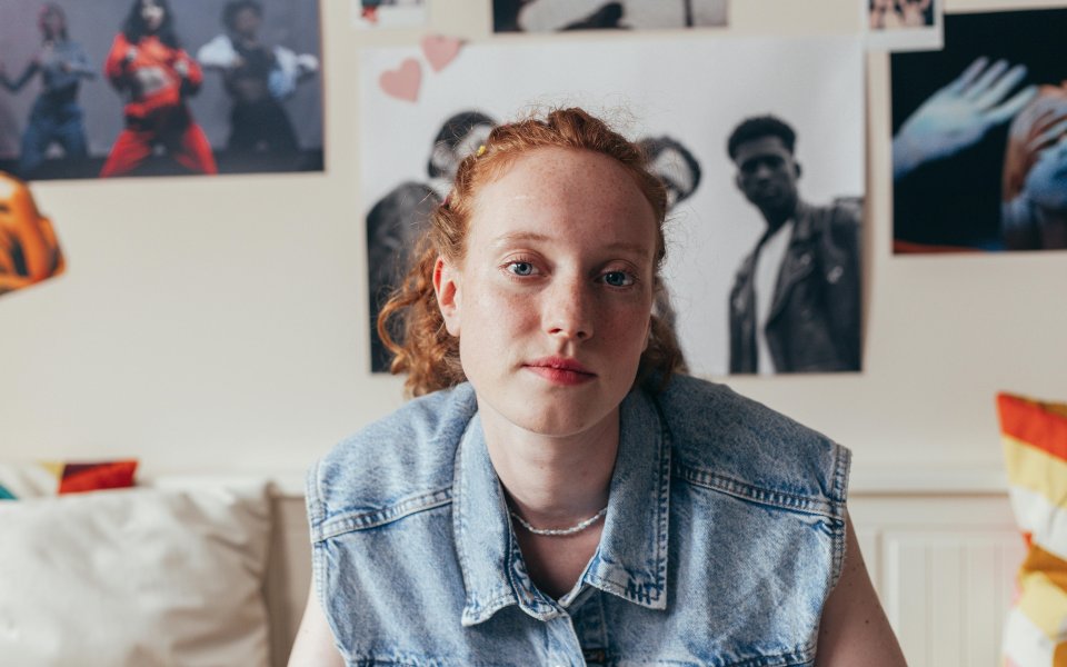 tiener-in-haar-kamer-met-posters-aan-de-muren