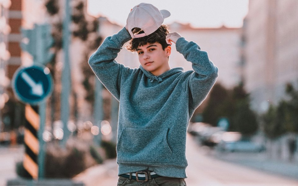 tiener-staat-op-straat--op-de-achtergrond-verkeersbord-met-pijl