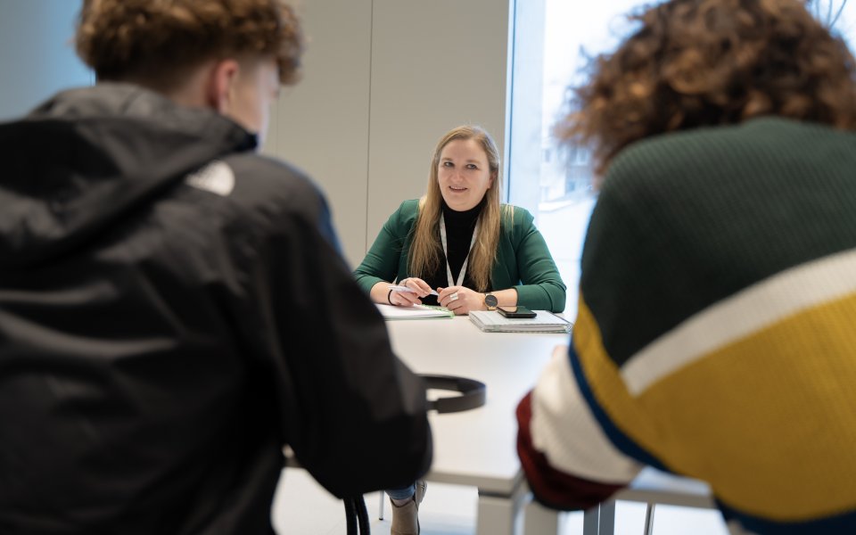 Tine in gesprek met een jongere en begeleider Lander