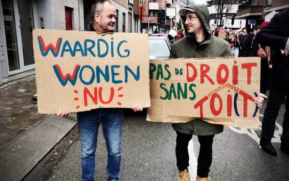 twee demonstranten op straat met slogans over het recht op waardig wonen