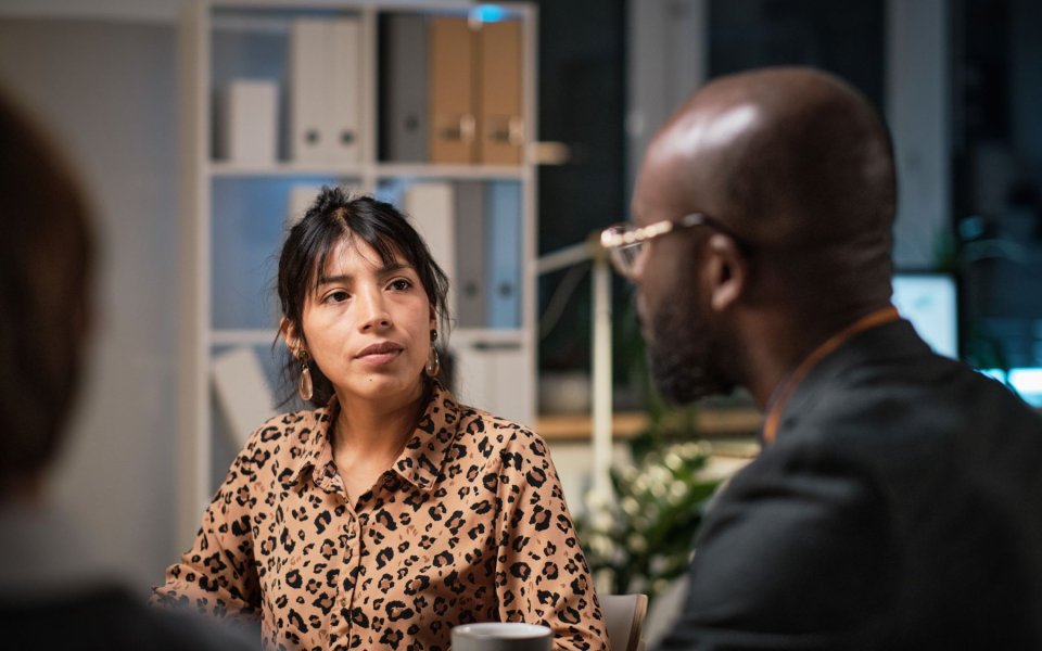Een vrouwelijke en mannelijke collega in gesprek, vrouw luistert aandachtig