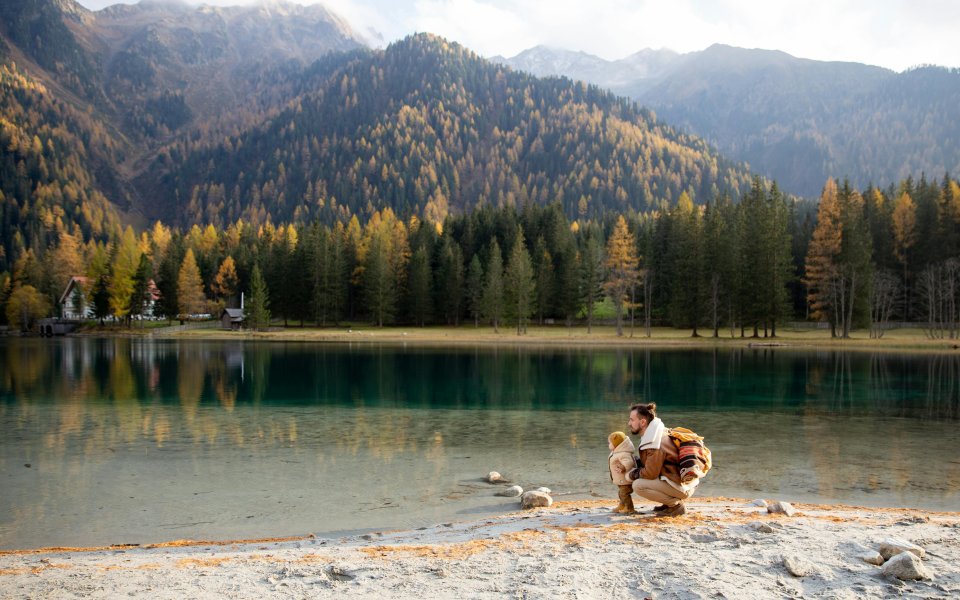 vader en peuter aan een meer in bergachtig landschap