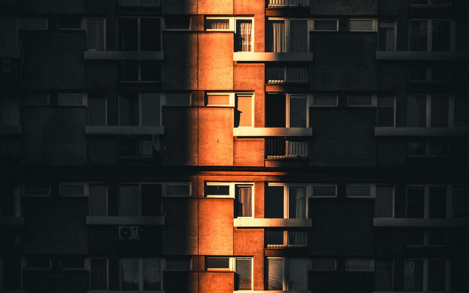 voorgevel appartementsblok deels in de schaduw