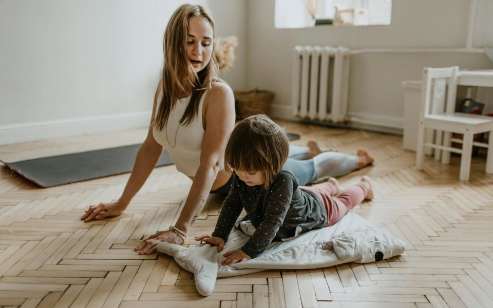 vrouw en meisje doen yoga op de grond