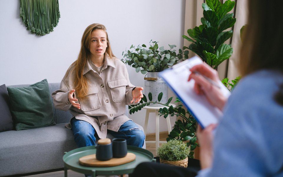 vrouw-in-gesprek-met-iemand-met-vragenlijst
