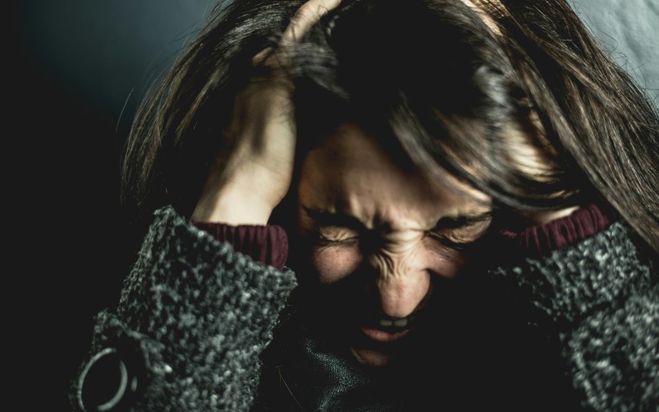 vrouw-met-handen-in-haar-haar--ogen-toegeknepen-en-roepend