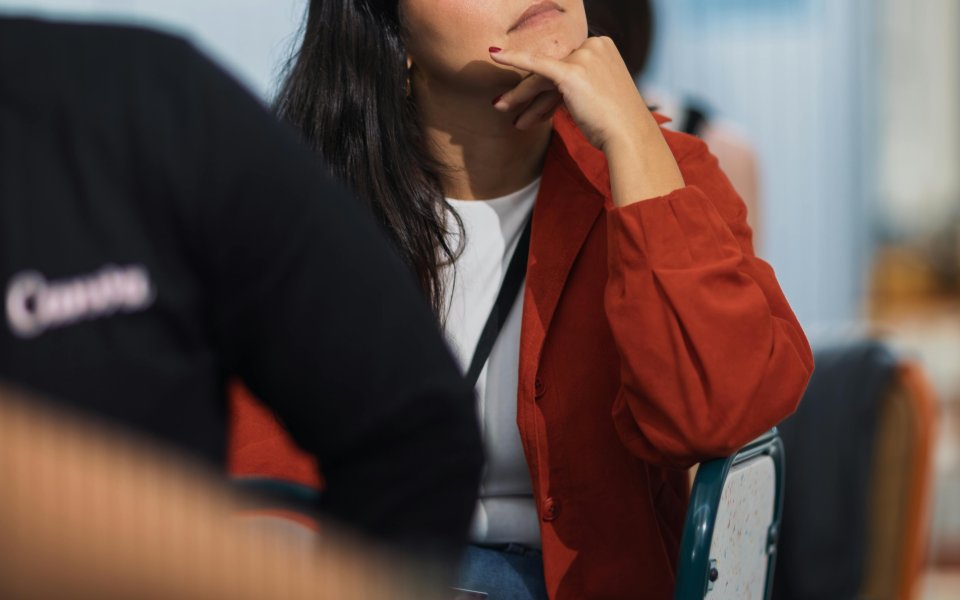 vrouw zit op stoel en luistert aandachtig