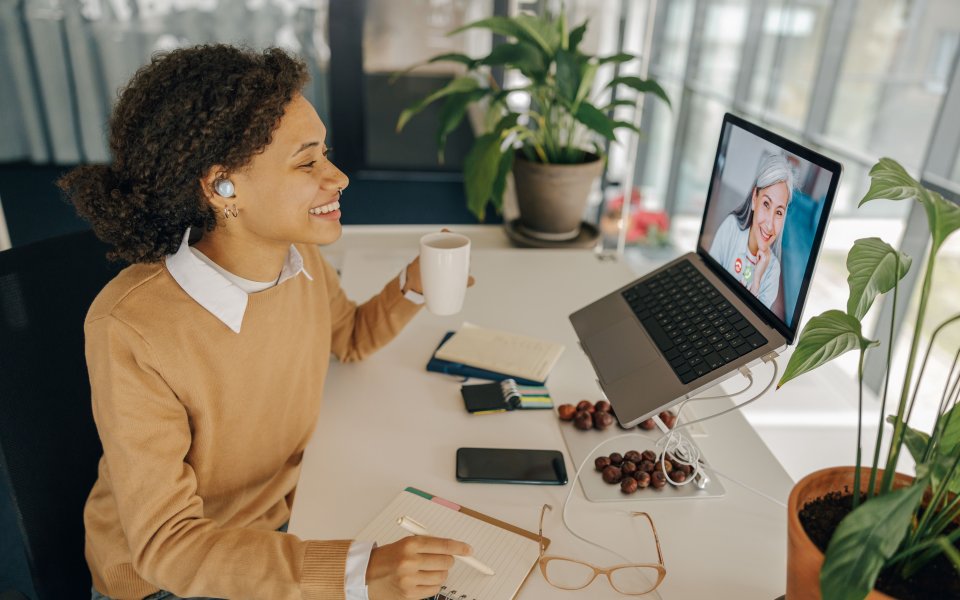 vrouw lacht laptop meeting