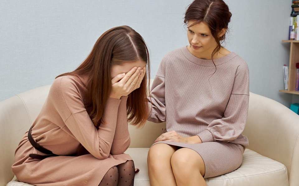 wenende vrouw op bank bij psychologe