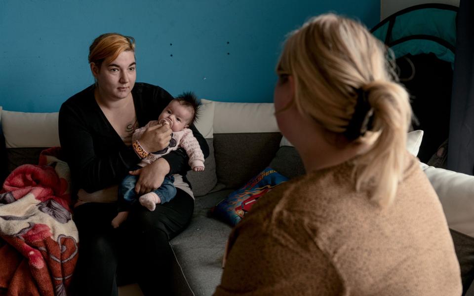 Gezinsondersteuner Melissa in gesprek met moeder die baby vasthoudt