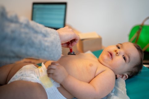 baby wordt onderzocht door arts met stethoscoop