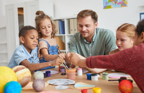 begeleider knutselt met een groep kinderen