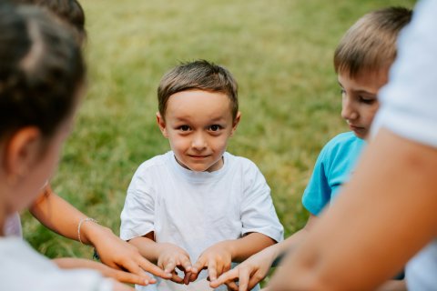 Groep kinderen speelt buiten in een kring