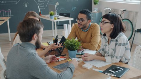 4 mannen en vrouwen werken samen rond een tafel
