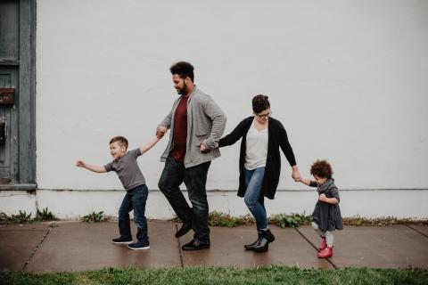 Familie wandelt hand-in-hand over straat, diversiteit, gezin, samenleving