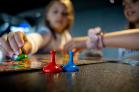 kinderen spelen bordspel met pionnen