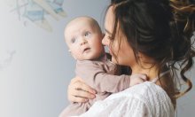 Jonge mama met baby op schouderhoogte