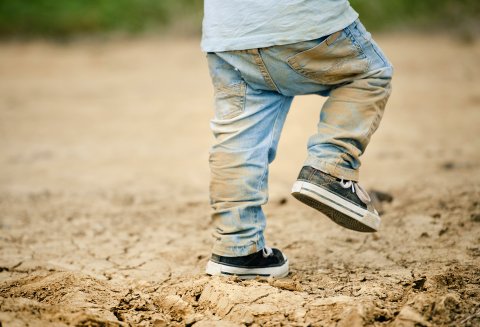Peuter buiten met broek vol modder