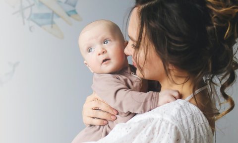 Jonge mama houdt pasgeboren baby vast
