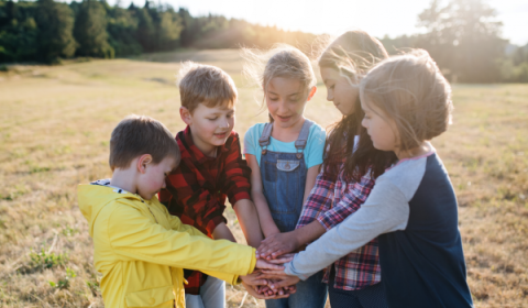 Kinderen staan in een kring met handen op elkaar