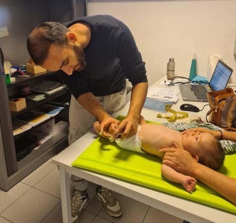 Zomerarts Sohrab onderzoekt tijdens een consultatie een baby