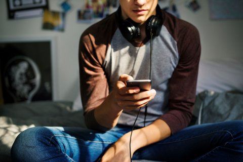 jongen luisterend naar muziek op smartphone