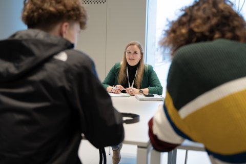 Tine in gesprek met een jongere en begeleider Lander