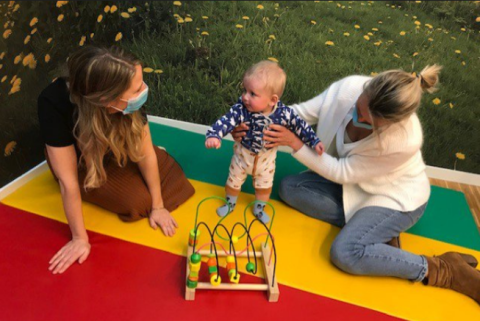 Goedele en Ellen met mondmasker, spelen met een baby